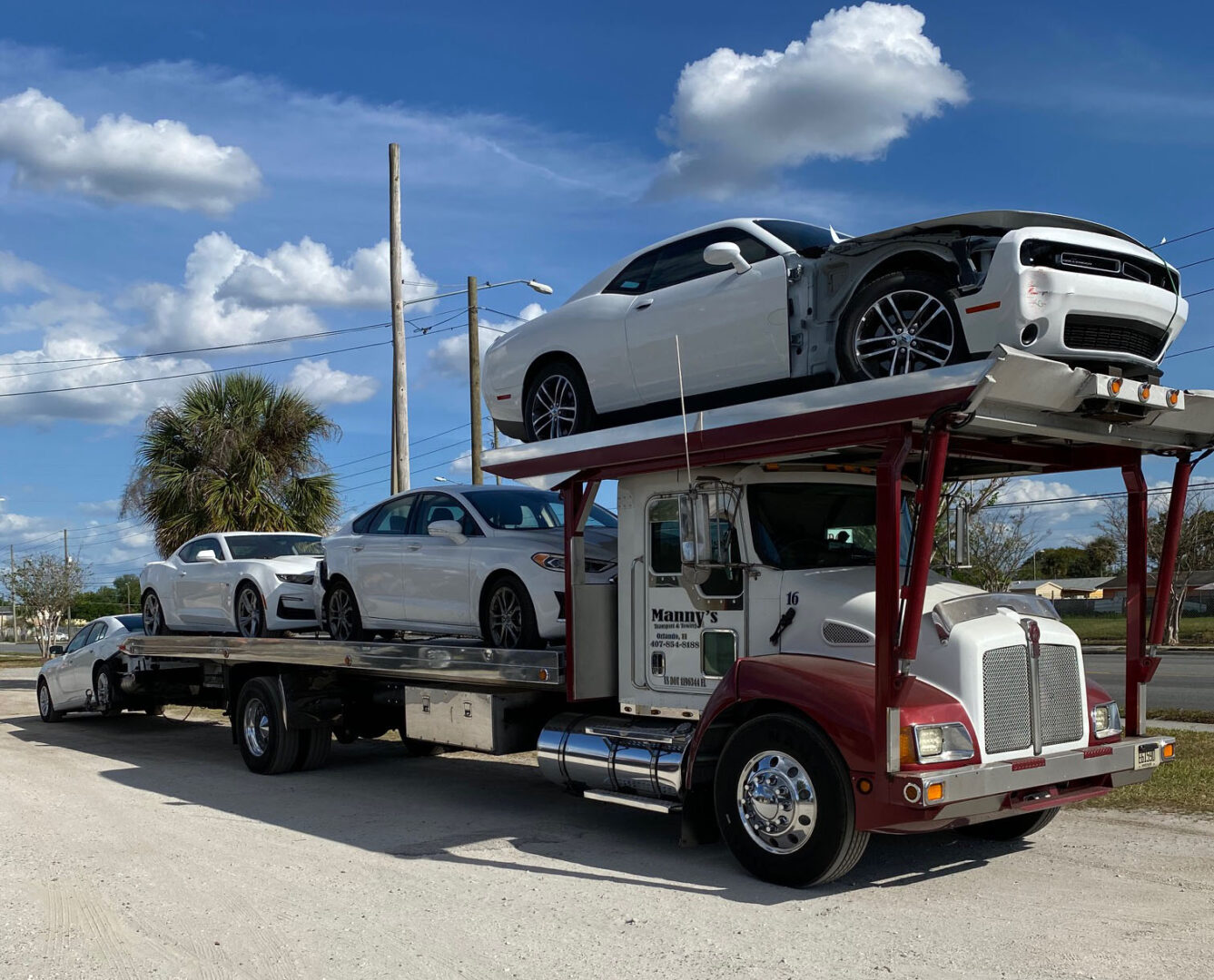 A truck carrying two cars on the back of it.